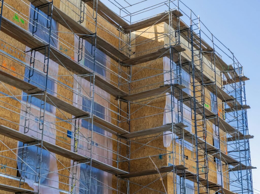 Home A high-rise building with scaffolding for construction and repair work under a clear sky.